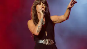 Ella Langley singing into a microphone under stage lights during a 2026 Dandelion Tour arena show