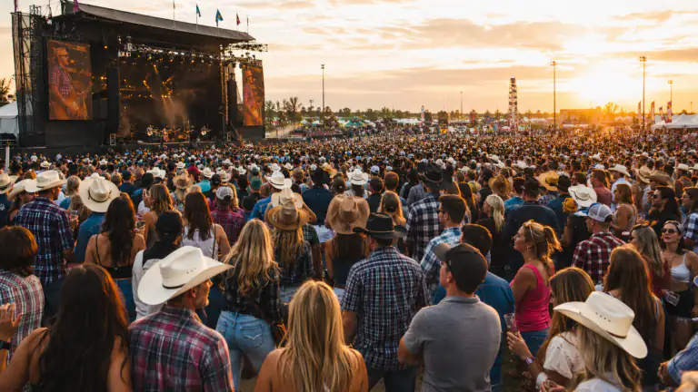 Golden hour crowd at an outdoor country music festival
